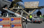 Des cartons contenant quelque 500.000 masques venus de Chine sont déchargés de l'avion  Air China, sur l'aéroport d'Athènes, le 21 mars 2020