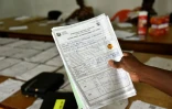 Un employé de la Commission électorale indépendante montre un document concernant les résultats du scrutin le 31 octobre 2016 à Abidjan