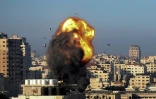 Une boule de feu et de la fumée s'élèvent dans le ciel après une frappe aérienne israélienne sur la ville de Gaza visant le complexe Ansar, lié au mouvement Hamas, dans la bande de Gaza, tôt le 15 mai 2021