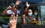 Un bus transportant des détenus libérés de la prison d'Insein à Rangoun passe devant la foule qui attend devant l'établissement, le 19 octobre 2021