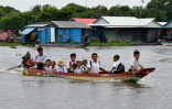 Des enfants reviennent de l'école dans leur village flottant de Prek Toal dans la province de Battambag, au Cambodge, le 14 octobre 2020