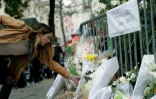 Une femme dépose un bouquet de fleurs près du Bataclan, le 14 novembre 2015