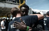 Cette photo distribuée par Médecins sans frontières et SOS Méditerranée montre un migrant de l'Aquarius donnant l'accolade à un sauveteur le 17 juin 2018 à Valence
