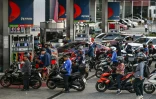Des motocyclistes et des automobilistes font la queue à une station-service à Quezon City, dans la région métropolitaine de Manille, le 9 mars 2026 aux Philippines