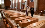 Un prĂȘtre bĂ©nit les cercueils de personnes dĂ©cĂ©dĂ©es du Covid-19, dans l'Ă©glise de San Giuseppe Ă Seriate, dans le nord de l'Italie, le 28 mars 2020