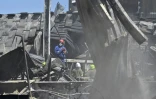 Les services de secours ukrainiens déblaient le 28 juin 2022 les débris du centre commercial Amstor de Krementchouk (centre) où une frappe russe a fait la veille une vingtaine de morts et des dizaines de blessés et disparus 
