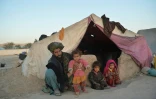 Les fillettes Farishteh, 6 ans, (d) et Shokriya (2g) un an et demi, avec leur père et leur frère, devant leur tente du camp de déplacés de Qala-i-Naw, le 14 octobre 2021 en Afghanistan