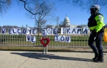 un policier passe devant une banderole souhaitant la bienvenue à la future vice-président Kamala Harris près du Capitole le 10 janvier 2021