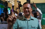 Hun Manet, pressenti pour remplacer son père comme Premier ministre après les élections, montre l'encre sur son doigt, après avoir voté aux législatives à Phnom Penh le 23 juillet 2023