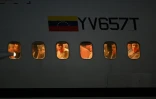 Des migrants vénézuéliens emprisonnés au Salvador regardent par les hublots de l'avion alors qu'il atterrit à l'aéroport international Simon Bolivar de Maiquetia, au Venezuela, le 18 juillet 2025