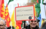 Un protestataire brandit une pancarte "L'Otan finance, Erdogan bombarde", durant une manifestation pro-kurde Ă Cologne, dans l'ouest de l'Allemagne, le 19 octobre 2019.