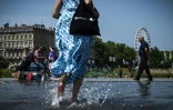Une femme passe sur le Miroir d'eau, le 28 juillet 2024 Ă Toulouse