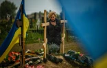 Une femme en deuil devant une tombe d'un cimetière à Kharkiv, le 21 mai 2022