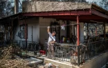 Un habitant répare les dégâts de l'incendie subi par sa maison dans le village de Neos Voutzas, près d'Athènes, le 28 juillet 2018.
