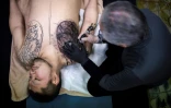 Le tatoueur japonais Horiyoshi III travaille sur un motif pour son client Kazuhide Okumura (à gauche), dans son studio de Yokohama, le 27 janvier 2018