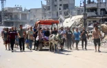 Des Palestiniens transportent près de la ville de Gaza le 22 juin 2024 les corps de proches tués lors d'un bombardement israélien