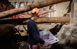 Une archéologue de la Ville de Paris examine le plan du site archéologique où un mur de Lutèce datant de l'époque gallo-romaine, a été découvert sous l'Hôtel-Dieu, dans le centre de Paris, le 23 septembre 2026
