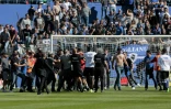 Des supporters bastiais envahissent la pelouse du stade Armand-Cesari pour tenter d'agresser le gardien de Lyon Anthony Lopes (rouge) à l'échauffement, le 16 avril 2017