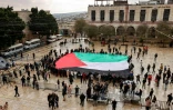 Un immense drapeau palestinien déplié sur la place de la Mangeoire, le 24 décembre 2023 dans l'eglise de la Naticité à Bethléem en Cisjordanie occupée