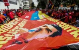 Des partisans de Nicolas Maduro tiennent un drapeau géant sur lequel figure le portrait du président vénézuélien lors d'une manifestation, le 18 octobre 2016 à Caracas