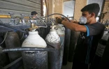 Des employés remplissent des bouteilles d'oxygène dans une usine à Taji, au nord de Bagdad, le 5 juillet 2020 en Irak
