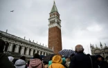 Des touristes regardent le campanile de Saint-Marc sur la place Saint-Marc à Venise, le 24 avril 2024.