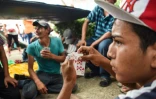 Des migrants honduriens jouent aux cartes Ă Mapastepec (sud du Mexique), le 24 octobre 2018.
Thousands of mainly Honduran migrants heading to the United States, a caravan President Donald Trump has called an "assault on our country", continued their march to the US after one-day rest in Huixtla, Chiapas state in Mexico.