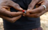 Un toxicomane tient un comprimé rouge à base de tapentadol à Abuja, le 24 février 2026 au Nigeria