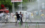 Des policiers lancent des gaz lacrymogènes et utilisent des canons à eau face à une foule d'adeptes du gourou lançant des pierres, le 25 août 2017 à Panchkula