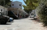 Des policiers et des migrants devant l'entrée du centre d'accueil de Lampedusa, le 21 août 2019, en Sicile