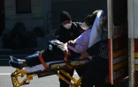 Des ambulanciers transportent un malade à l'hôpital de Brooklyn, le 27 mars 2020 à New York