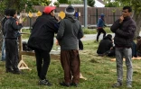 Des Afghans se rasent devant une installation sanitaire mobile, le 5 septembre 2017 à Calais