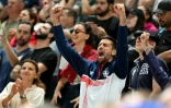 Novak Djokovic (c), qui rencontre Rafael Nadal au deuxième tour du tournoi olympique de tennis, encourage l'équipe de Serbie de volleyball, le 28 juillet 2024 à Paris