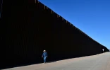 L'éleveur John Ladd marche le long du mur frontalier entre les Etats-Unis et le Mexique, le 17 avril 2024 près de Palominas,en Arizona