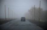 Une voiture roule sur une route protégée par des filets antidrones, près de Kramatorsk, dans l'est de l'Ukraine, le 10 octobre 2025 