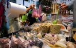 Un commerçant met des produits dans un sac en plastique sur un marché de Keelung, à Taïwan, le 9 juin 2026
