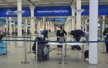 Des voyageurs équipés de masques de protection remplissent un formulaire au terminal de l'Eurostar de St Pancras, le 8 juin 2020 à Londres