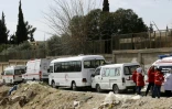 Des ambulances du Croissant rouge syrien attendent une éventuelle évacuation de blessés de l'enclave rebelle dans la Ghouta orientale, au passage d'Al-Wafidine, le 1er mars 2018