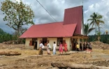 Des villageoisquittent l'église protestante d'Angkola après la messe de Noël, dans le village d'Aek Ngadol, le 25 décembre 2025, dans la province de Sumatra touchée par des inondations et glissements de terrain meurtriers, en Indonésie