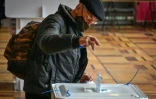 Un homme glisse son bulletin dans l'urne le 17 septembre 2021 à Moscou
