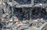 Des Palestiniens assis au milieu des décombres d'une mausin dans le camp de réfugiés de Nuseirat, dans la bande de Gaza, le 20 mars 2024