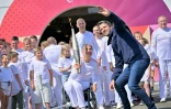 Le président du Comité d'organisation des Jeux (Cojo) Tony Estanguet (D) prend un selfie avec Emmanuelle Assmann porteuse de la flamme paralympique, le 25 août 2024 à Coquelles dans le Pas-de-Calais