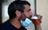 Un homme boit une bière en terrasse à Séville (Espagne) le 13 août 2020