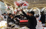 Des bénévoles distribuent des bouquets de fleurs aux futurs mariés lors d'une cérémonie de mariage collectif à Kaboul, le 25 décembre 2023 en Afghanistan