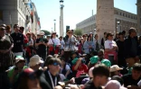 Des personnes suivent les funérailles du pape François sur un écran installé Via della Conciliazione, près du Vatican, le 26 avril 2025 à Rome