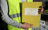 Un "gilet jaune" montre le cahier de doléances qu'il présente sur un rond-point à Cagnes-sur-mer, le 20 décembre 2018