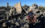 Des hommes récupèrent des objets au milieu des ruines d'un bâtiment après un bombardement israélien, le 13 janvier 2024 à Rafah dans la bande de Gaza