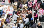 Des volontaires distribuent de la nourriture et des boissons après qu'un important incendie a ravagé plusieurs immeubles d'appartements du complexe résidentiel Wang Fuk Court,  à Hong Kong, le 27 novembre 2025