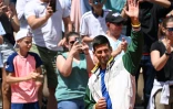 Le Serbe Novak Djokovic (au centre) salue les spectateurs du tournoi de Roland-Garros avant un match exhibition sur la terre battue parisienne le 27 mai 2023