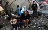 Des habitants de Gaza dans les ruines d'une école abritant des déplacés touchée par une frappe israélienne, à Gaza-ville le 15 janvier 2025